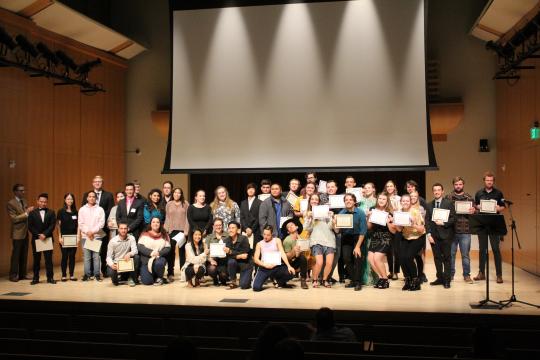 students on stage holding certificates 