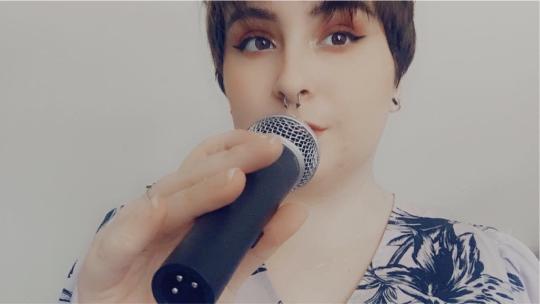 Abbi Samuels holding a microphone to her mouth