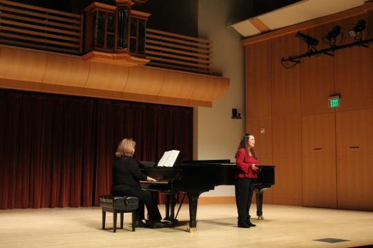 student singing on stage with accompanist