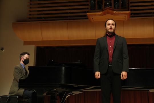 Singer singing on Schroder stage in front of piano with accompanist