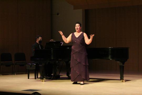 Alfie Halpern singing on stage at SSU with piano accompanist