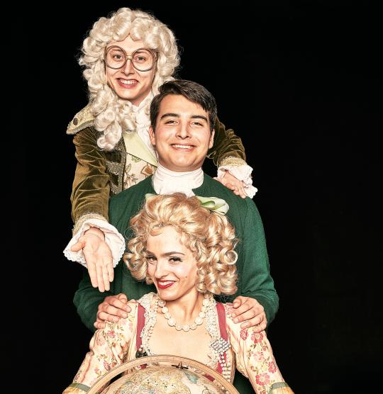 Three actors dressed in period costumes in a vertical line