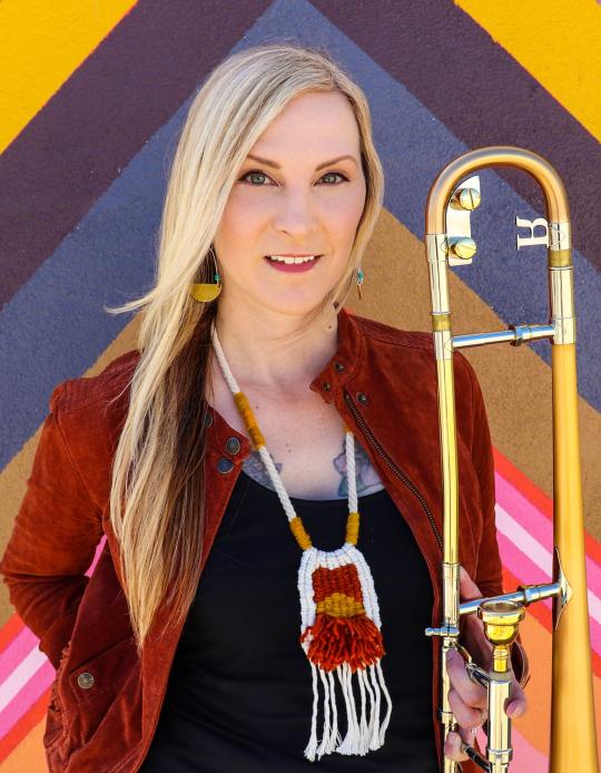 Jeanne Geiger Headshot holding trombone