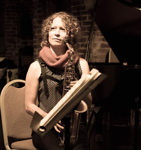 Kasey Knudsen sitting and holding a saxophone