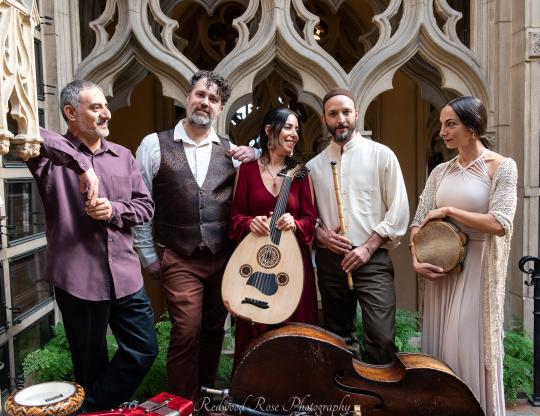 The Qadim Ensemble holding instruments in a courtyard