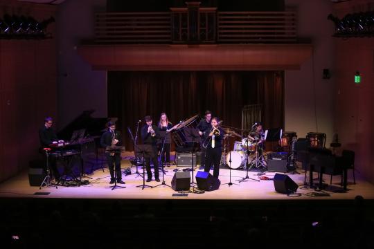 Band playing on stage with purple light