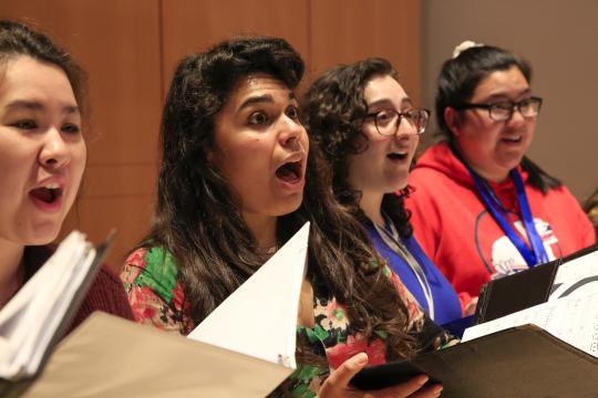 Women singing with choral folders