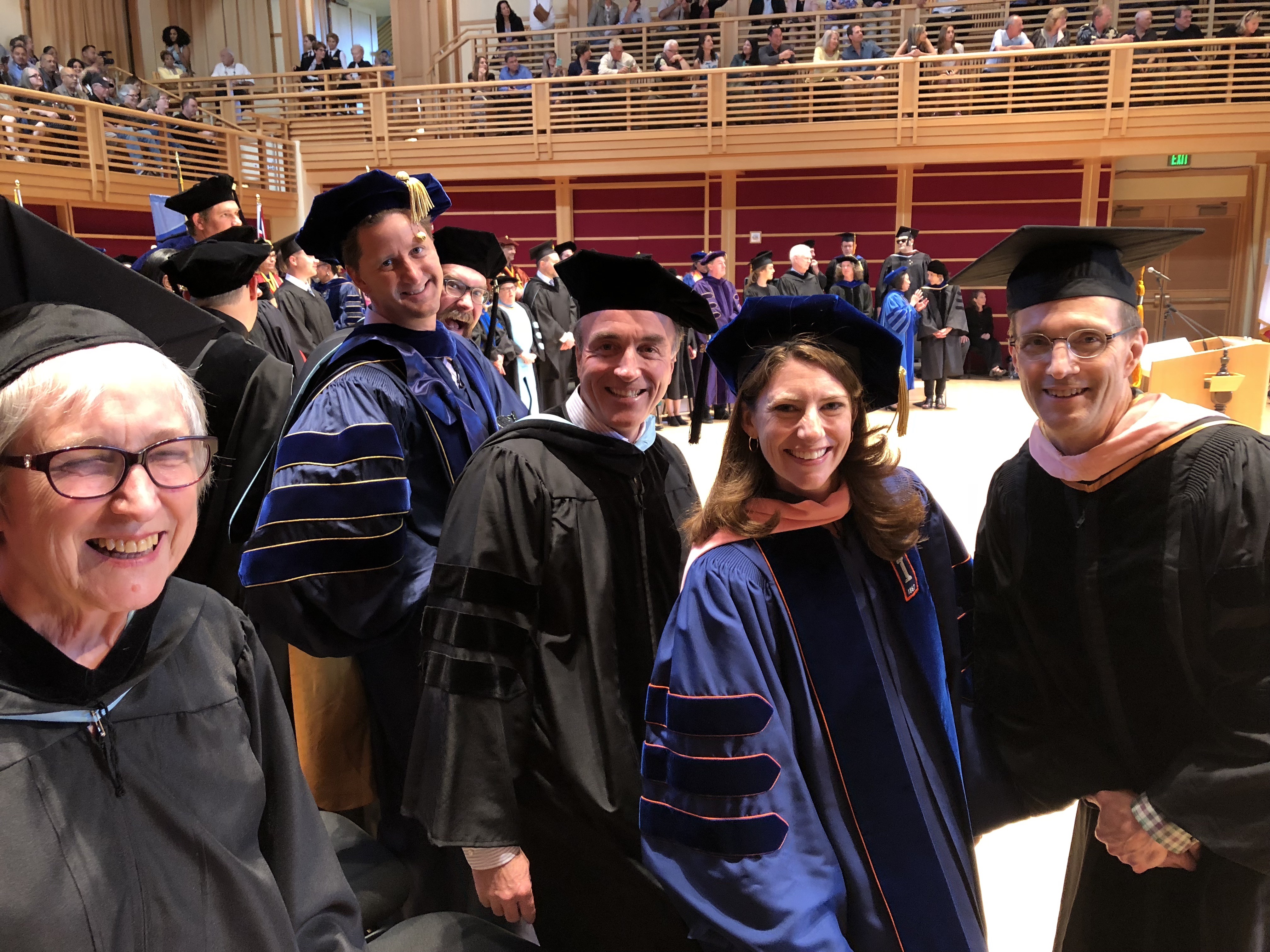 Faculty dressed in graduation regalia on stage in Weill Hall