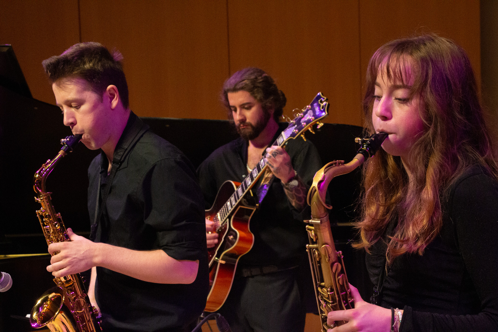 two saxophonists and a guitarisht performing