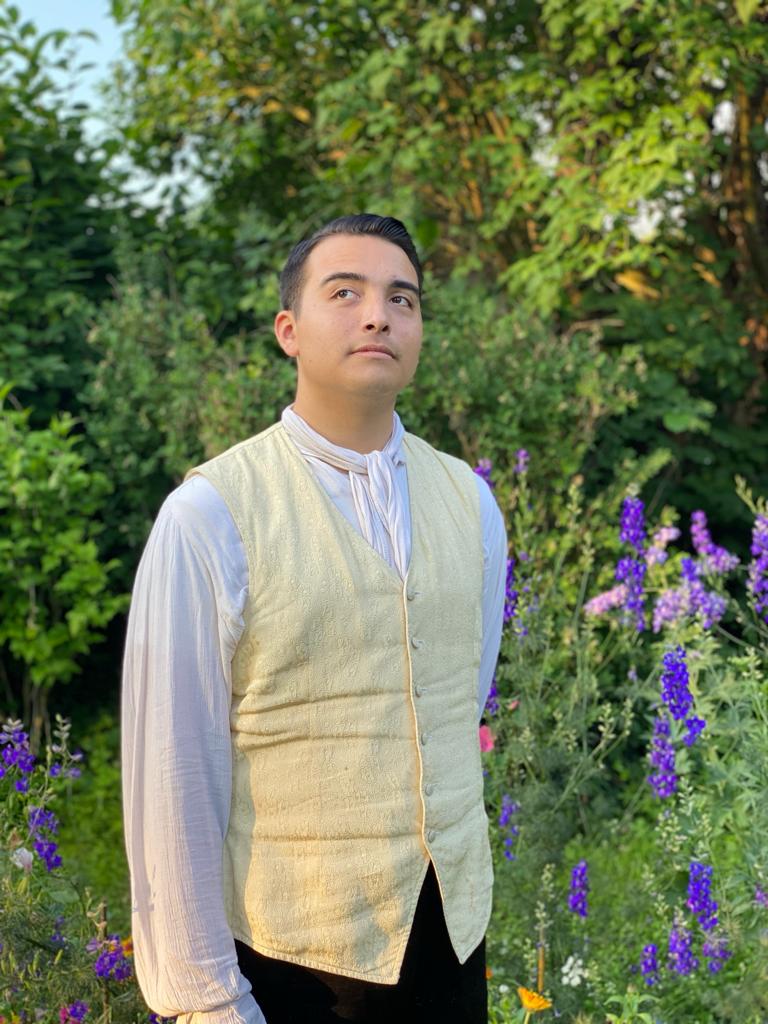 Jack Adkins in costume standing outside amongst purple flowers and trees