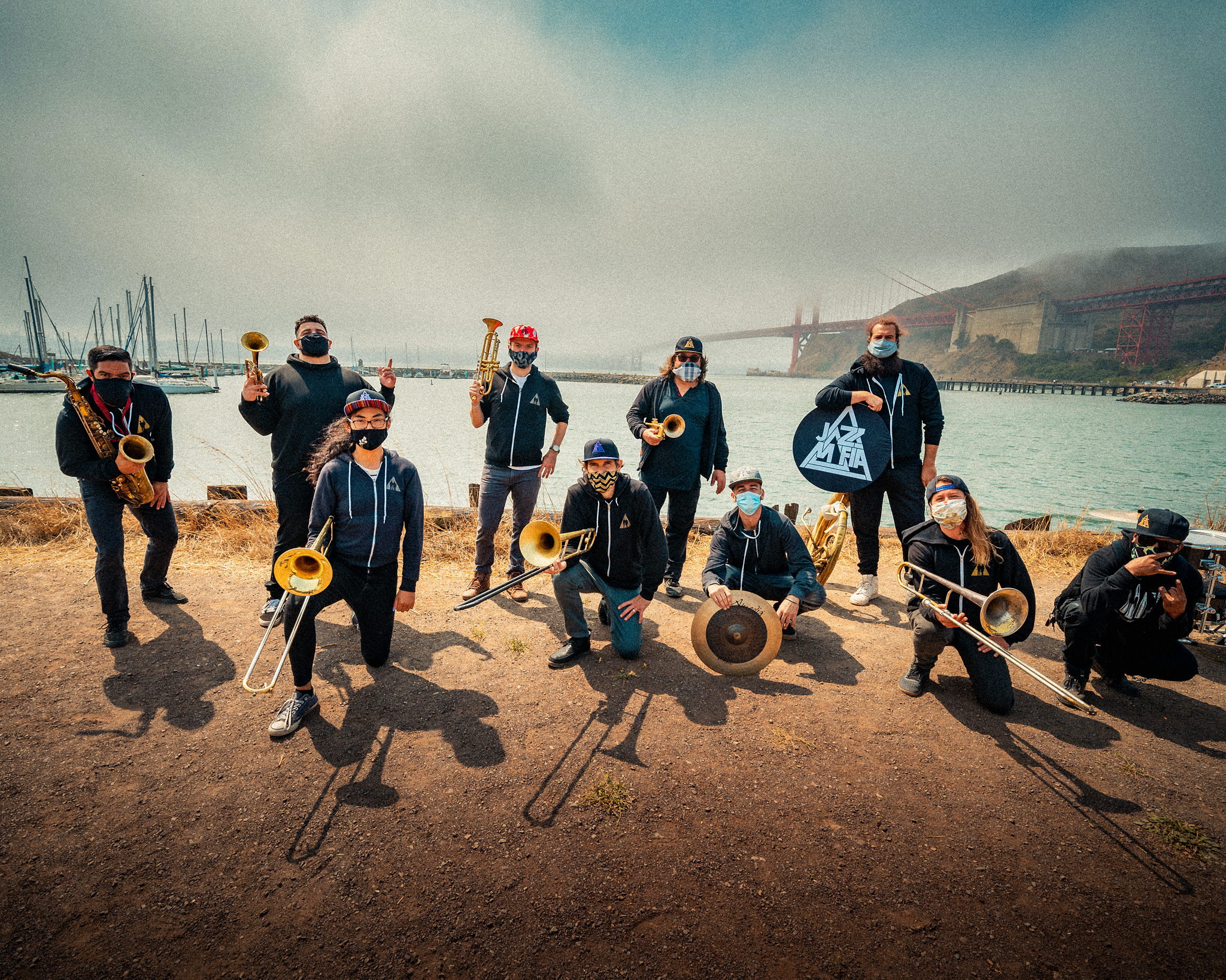 Band posing with instruments by the water