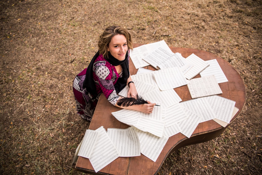 Christa Durand sitting in front of a table of sheet music