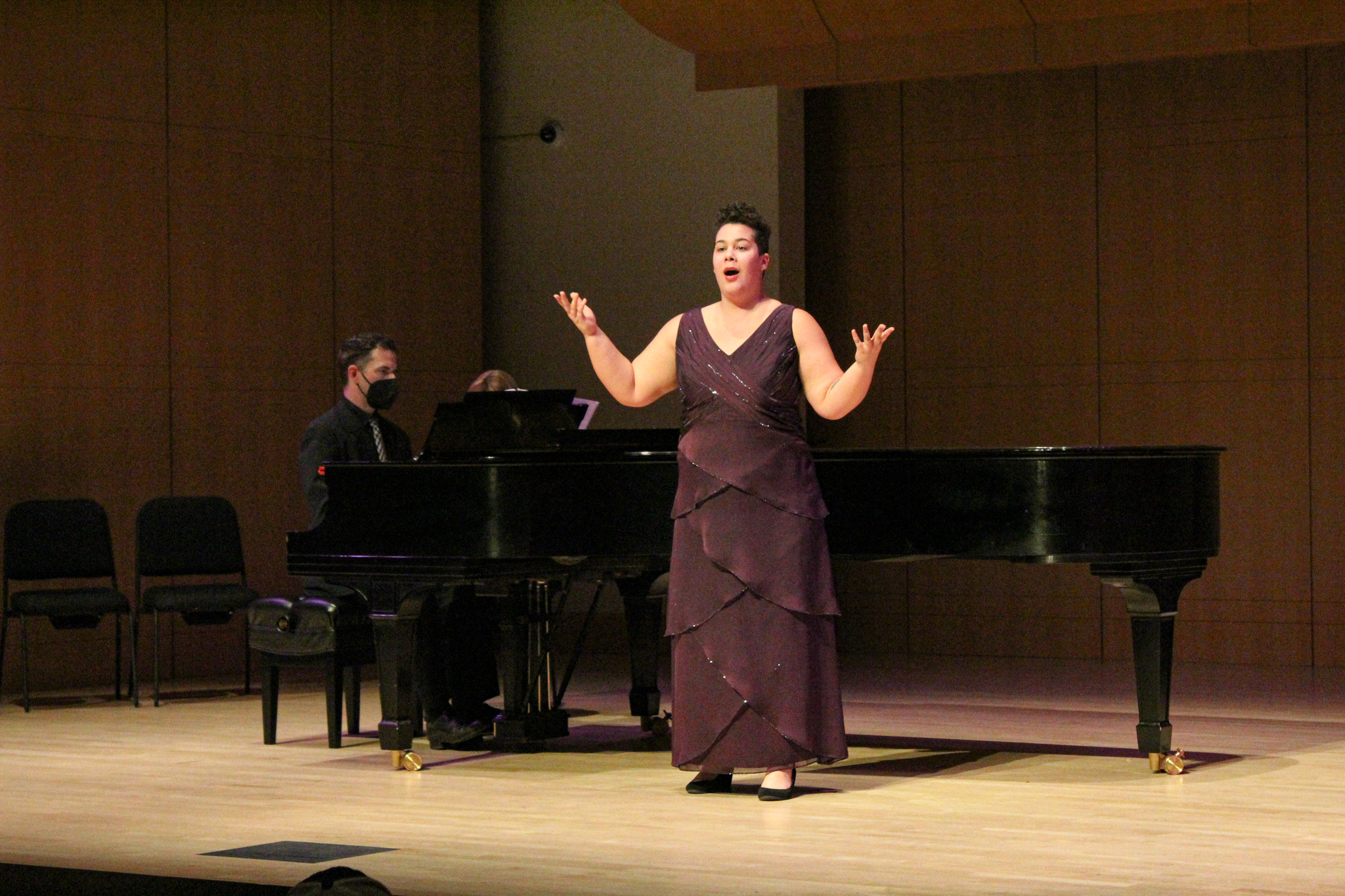 Singer on stage performing with piano accompaniment