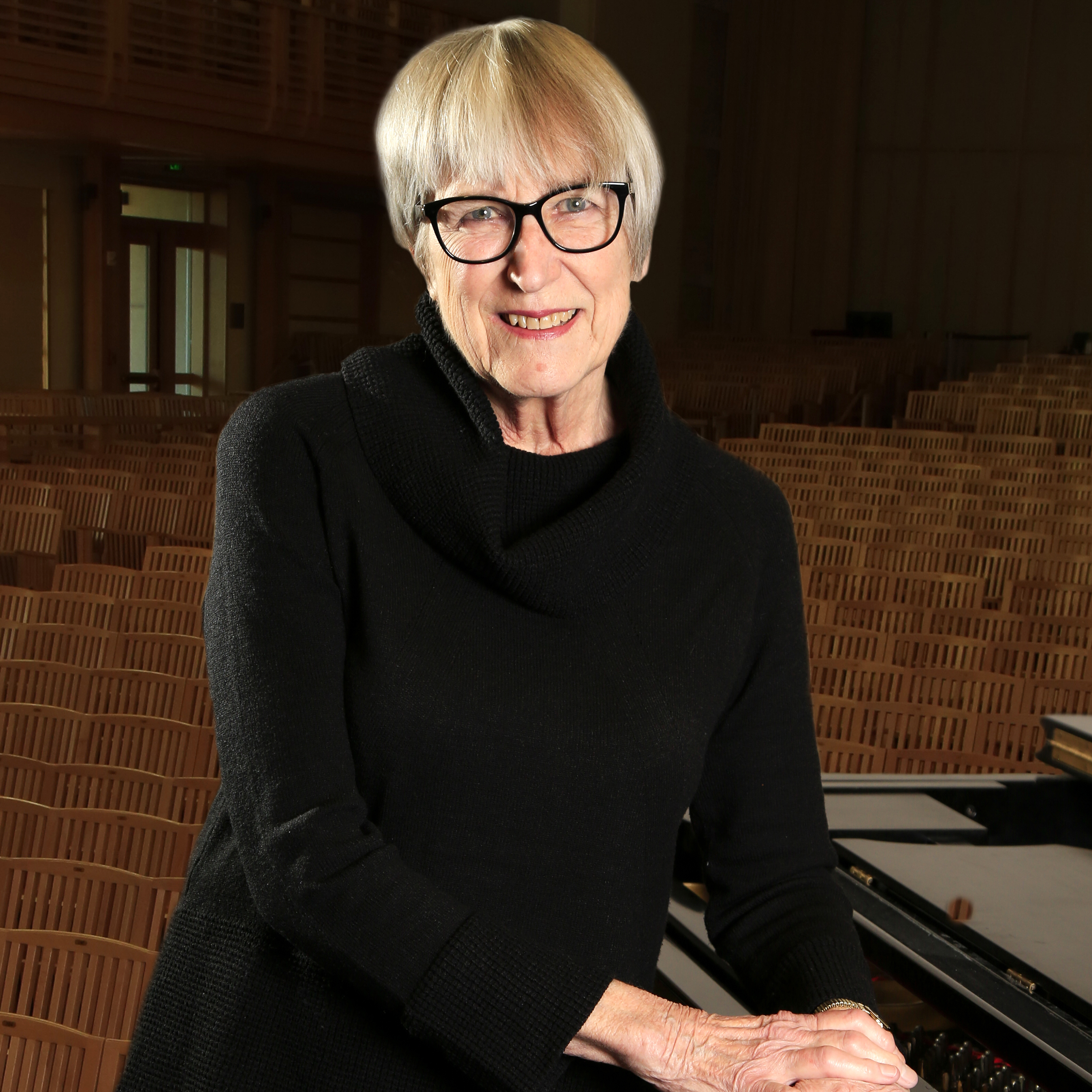 Marilyn Thompson Headshot leaning on piano